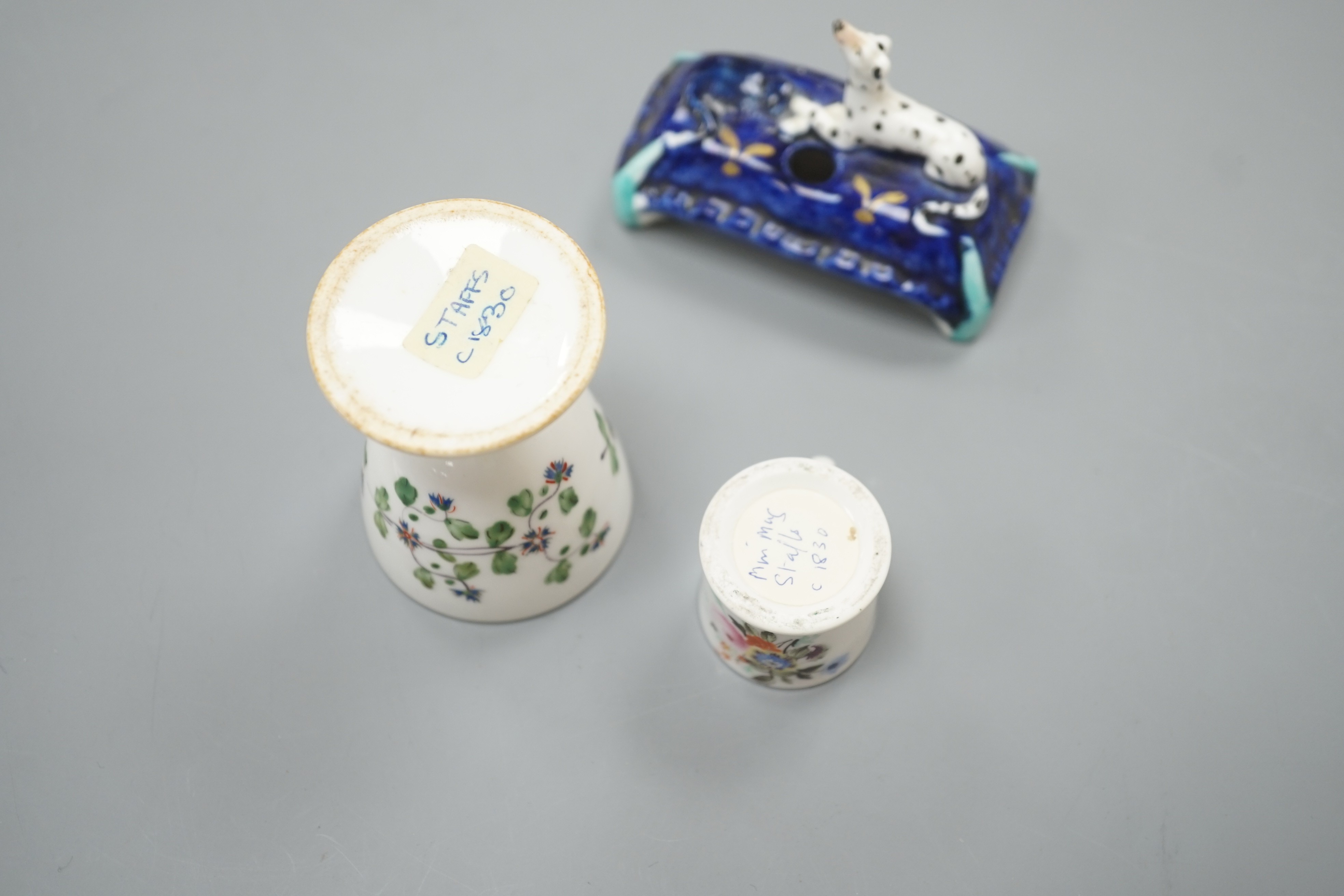 A mid 19th century Staffordshire porcelain Dalmatian pen holder and a cornflower spray egg cup and a miniature mug, tallest 6cm